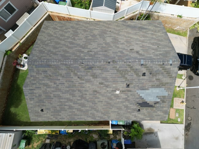 Wind-damaged asphalt shingle roof following Hurricane Lala on Oahu